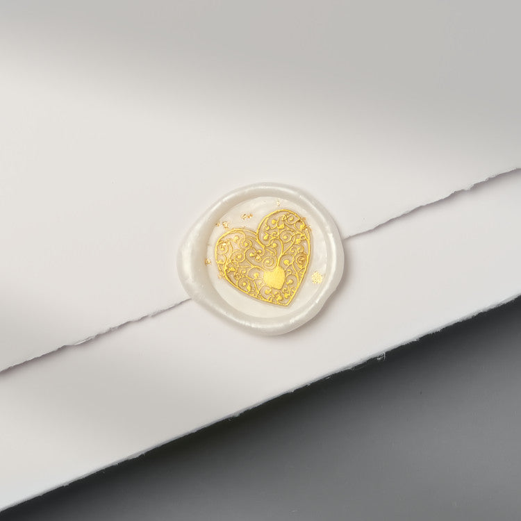 Stilvolles Wachssiegel mit dem Motiv „Goldenes Herz“ auf Einladung aus handgeschöpftem Büttenpapier.
