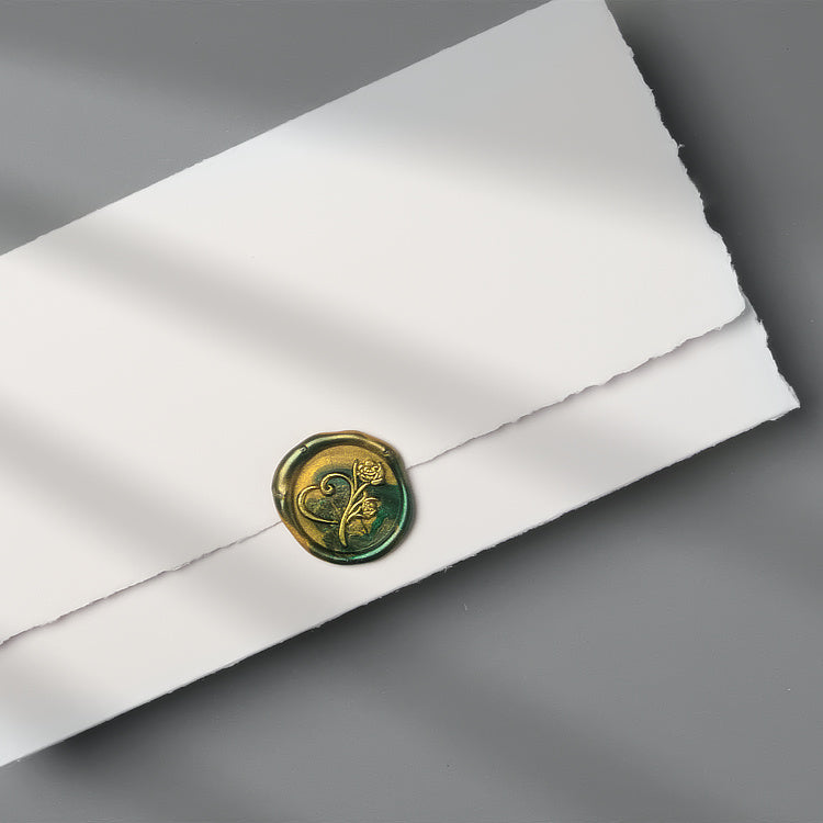 Elegantes Grün-Gold marmoriertes Wachssiegel mit dem Motiv Rose mit Herz mit goldenen Details auf einer Einladung.