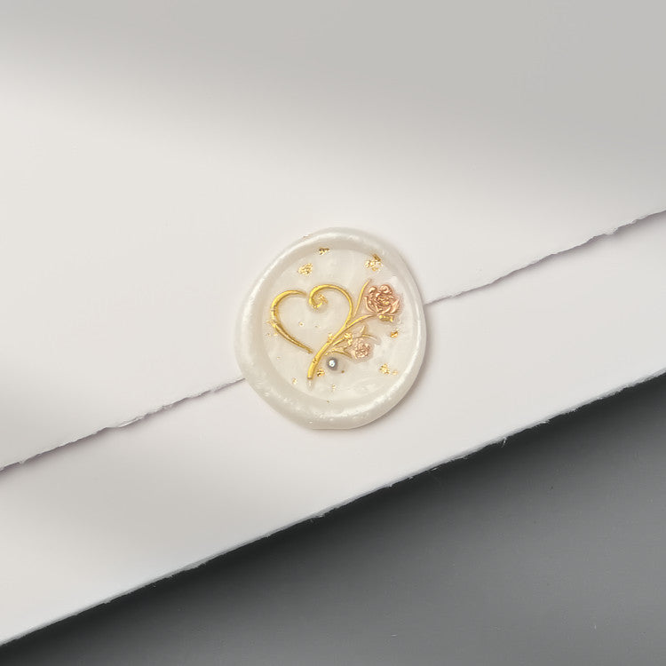 Perfekt für Einladungen zur Perlenhochzeit: Wachssiegel „Herz mit Rose“ in Perlmutt mit Goldflocken und einer Perle.