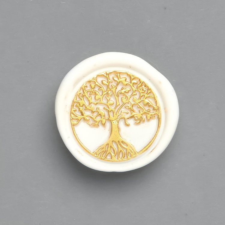 Ein weißes Wachssiegel mit goldenem Design „Baum“. Die filigranen Äste und Wurzeln symbolisieren Leben und Stärke.