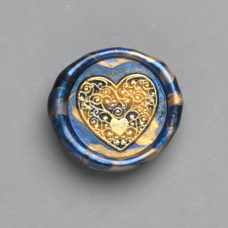 Blau-Gold marmoriertes Wachssiegel mit dem Motiv Goldenes Herz veredelt mit goldenen Akzenten für Geschenkverpackungen.