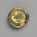 Florales Wachssiegel in Grün-Gold mit dem Motiv „Große Liebe“ mit goldener Rose für stilvolle Einladungen.