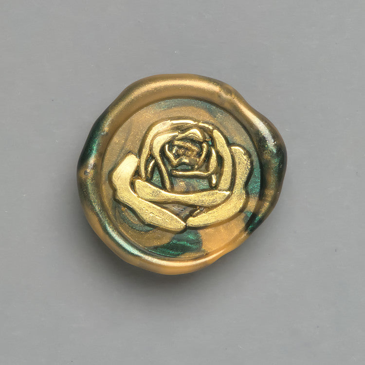 Florales Wachssiegel in Grün-Gold mit dem Motiv „Große Liebe“ mit goldener Rose für stilvolle Einladungen.
